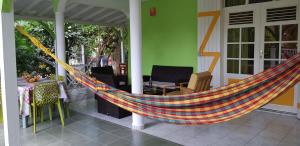 een hangmat op een veranda van een huis bij La Belle Créole in Sainte-Anne