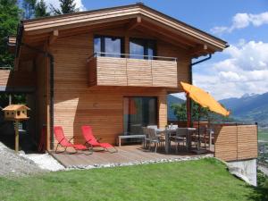 ein Haus mit einer Terrasse mit einem Tisch und Stühlen in der Unterkunft KirchnerKitz in Piesendorf