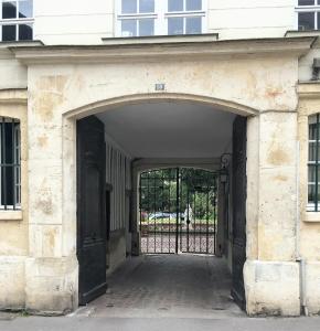 einen Eingang zu einem Gebäude mit einem schwarzen Tor in der Unterkunft Le Paradis Perdu in Rouen