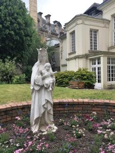 eine Statue einer Frau, die ein Kind im Garten hält in der Unterkunft Le Paradis Perdu in Rouen