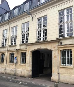 ein altes Gebäude mit einer schwarzen Tür auf einer Straße in der Unterkunft Le Paradis Perdu in Rouen