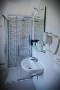 a bathroom with a glass shower and a sink at Hotel Jesolo Sand in Lido di Jesolo