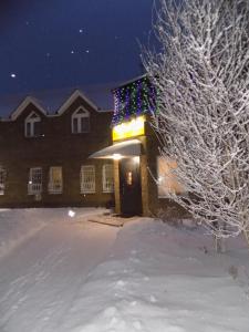 SalavatにあるSalavat Motelの雪中のクリスマス灯が付いた建物