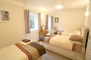 um quarto com 3 camas e uma janela em The Wriggly Tin, Millers Dale em Buxton