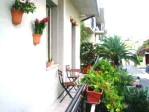a balcony with chairs and potted plants on a building at B&b Bed And Roses in Montesilvano