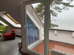 a sliding glass door in a room with a balcony at Ferienwohnung Seeblick, Ferienanlage "Blaumuschel" in Lubmin