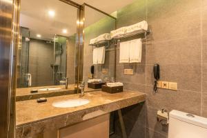 a bathroom with a sink and a mirror at Chengdu Jiuzhaigou Hotel in Chengdu
