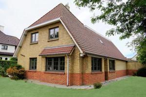 une maison en briques avec un toit brun dans l'établissement villa mezennestje, à Oostduinkerke