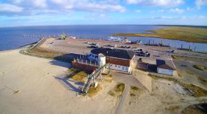 an aerial view of a building on the beach at Huus Wattenmeer in Neßmersiel an der Nordsee in Dornum