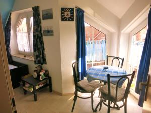 a dining room with a blue table and chairs at Huus Wattenmeer in Neßmersiel an der Nordsee in Dornum +34 photos
