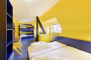a yellow room with a bed and a chair at Bed’nBudget Expo-Hostel Dorms in Hannover