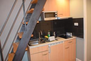 a small kitchen with a sink and a microwave at Kudamm Apartments in Berlin