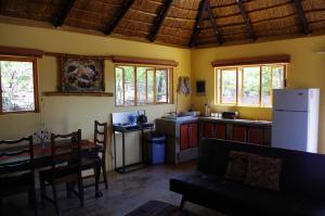 a kitchen and dining room with a table and a refrigerator at Bosveldsig Cottages in Modimolle