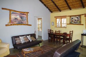 a living room with a couch and a table at Bosveldsig Cottages in Modimolle +34 photos