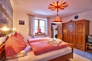 1 Schlafzimmer mit 2 Betten mit roten und weißen Kissen in der Unterkunft Landhaus Carolin Göhl in Bad Hindelang
