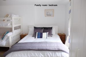 a bedroom with a white bed with pillows at Welsh Cosy Apartments in Llandudno