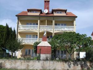 duży żółty dom z czerwonym dachem w obiekcie Apartments Grgic w mieście Novigrad