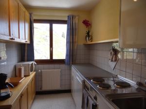 Una cocina con estufa, fregadero y ventana. en Arolles 303, en Arolla
