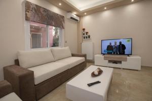 salon z kanapą i telewizorem z płaskim ekranem w obiekcie Spacious & convenient place near Acropolis Museum by GHH w Atenach