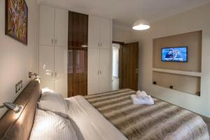 sypialnia z dużym łóżkiem i telewizorem w obiekcie Spacious & convenient place near Acropolis Museum by GHH w Atenach