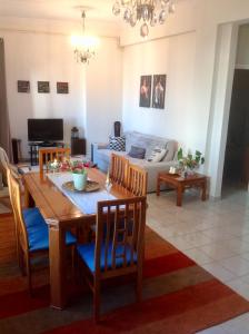 comedor y sala de estar con mesa y sillas en Perfect View, en Pireo