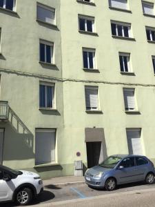 two cars parked in front of a building at Immeuble La DOA proche CHU in Saint-Priest-en-Jarez