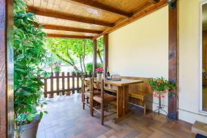 een patio met een houten tafel en stoelen bij bungalow campeggio madonnina in Domaso