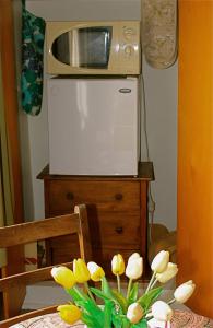 a vase of yellow flowers on a table with a microwave at Borough B&B in Eaglehawk