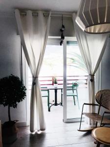 an open door with curtains and a table on a patio at Sweethomeadeje Apartment in Adeje