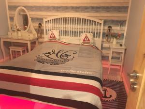 加茨比亞格拉的住宿－Apartament LAZUR，一间卧室,床上有竖琴的赌博标志