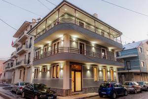 un gran edificio con coches estacionados frente a él en KorcaSmileHotel, en Korçë