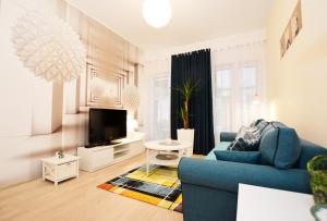 salon z niebieską kanapą i telewizorem w obiekcie Apartamenty Bałtycka6 w Kołobrzegu