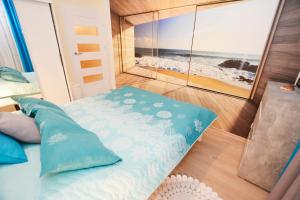 sypialnia z łóżkiem i widokiem na plażę w obiekcie Apartamenty Bałtycka6 w Kołobrzegu