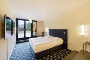 pokój hotelowy z łóżkiem i dużym oknem w obiekcie Hotel Wiehberg w Hanowerze