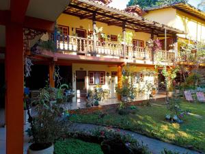 a house with a balcony and a yard with plants at Portal dos Borbas in Abraão