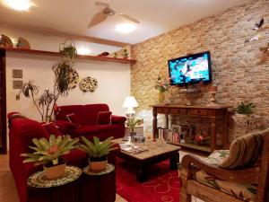 a living room with red furniture and a brick wall at Portal dos Borbas in Abraão