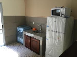 a kitchen with a sink and a microwave on top of a refrigerator at Apartamento para 8 personas frente a la plaza principal Mercedes Uruguay in Mercedes