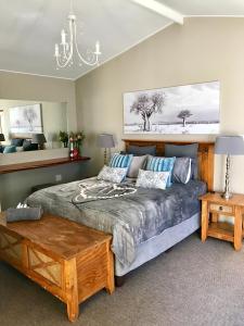 een slaapkamer met een bed en een kroonluchter bij Meadow Lane Country Cottages in Underberg