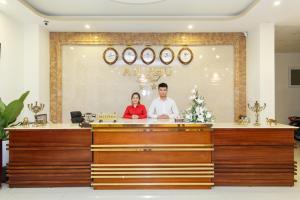 a man and a woman standing behind a counter at An Phu Hotel Da Lat in Da Lat