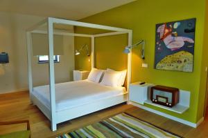 una camera con un letto a baldacchino bianco e una TV di Quinta das Lavandas a Castelo de Vide