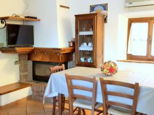 una sala da pranzo con tavolo e camino di Belvilla by OYO Casa Le Meridiane a Chiusdino