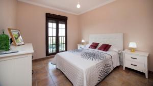 a bedroom with a white bed and two windows at Leo Rentals in Isla Canela +50 photos