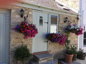 a stone house with flowers on the door at The Barn in Monk Fryston