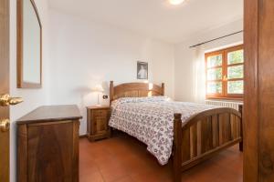 um quarto com uma cama, uma mesa e uma janela em Rustico dei vini em Domaso