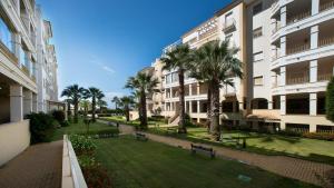 a park with palm trees in front of buildings at Leo Rentals in Isla Canela