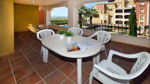 a white table and chairs on a balcony at Leo Rentals in Isla Canela