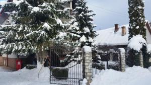 una cerca cubierta de nieve frente a una casa en Csaki Vendeghaz, en Sovata