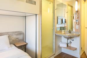 Un dormitorio con una cama, un lavabo y un espejo. en ibis budget Sorocaba, en Sorocaba 86 fotos más