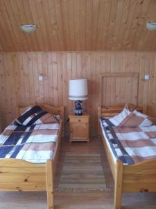 a room with two beds and a lamp in a cabin at Pokoje gościnne Janina i Józef Majdańscy in Kluszkowce