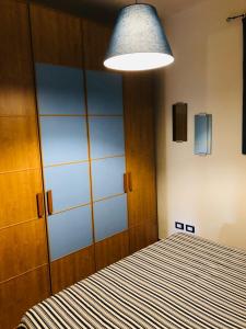 プンタ・アーラにあるPunta Ala - Tra mare e naturaのベッドルーム1室(ベッド1台、大きな照明付)